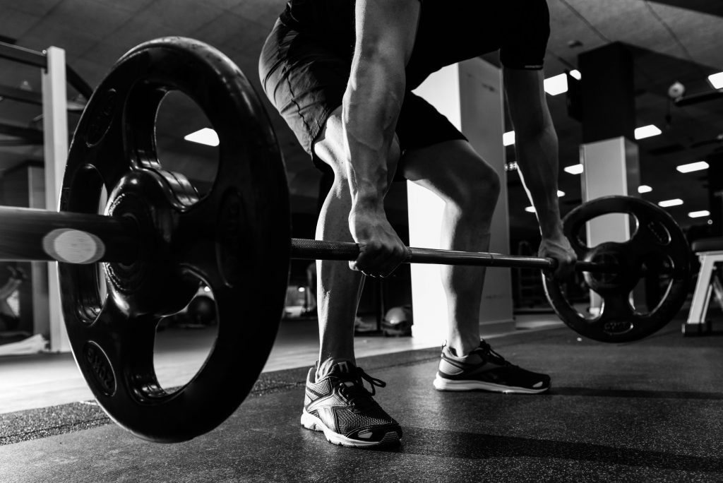 Closeup of weightlift workout at the gym with barbell.